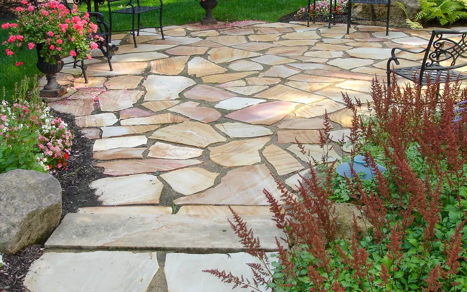 Irregular flagstone walk with flowering plants along the edge
